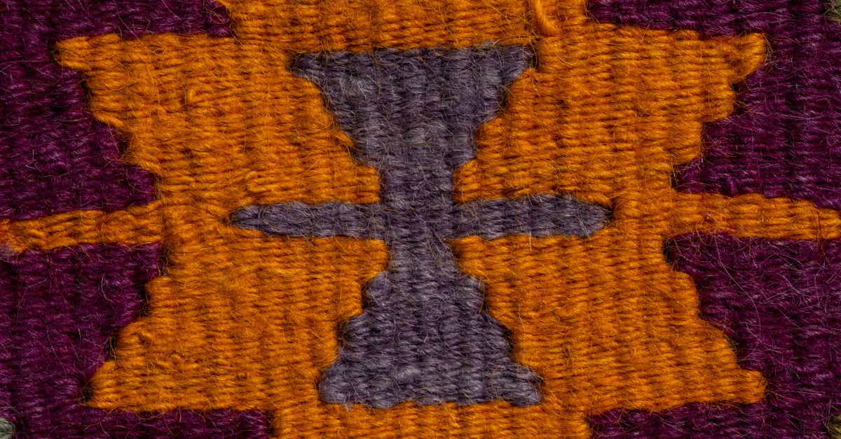 Detailed closeup of a colorful and traditional Turkish rug pattern, showcasing intricate design and texture.